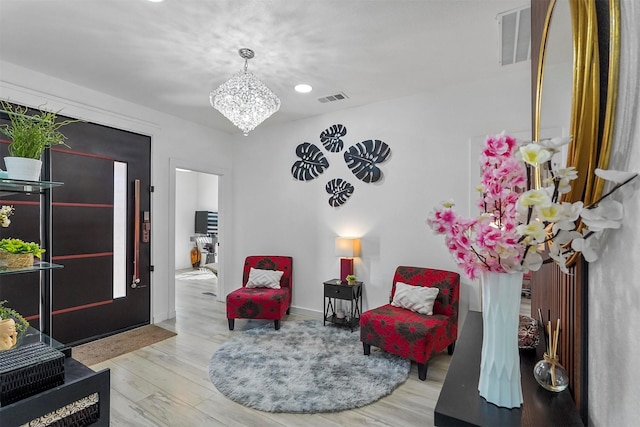 sitting room with a notable chandelier and light hardwood / wood-style floors