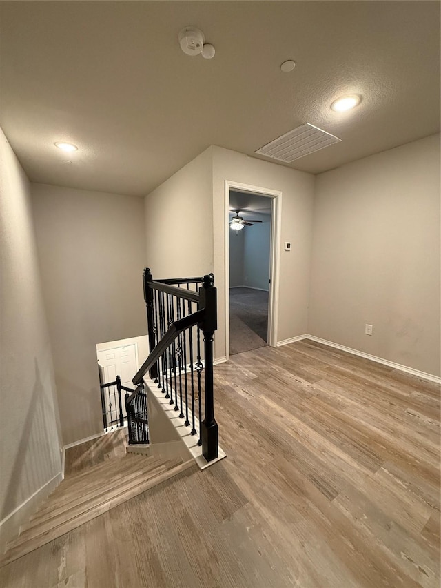 unfurnished room featuring visible vents, a textured ceiling, baseboards, and wood finished floors