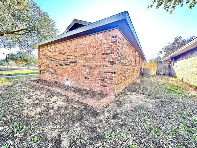 view of side of home with central AC unit