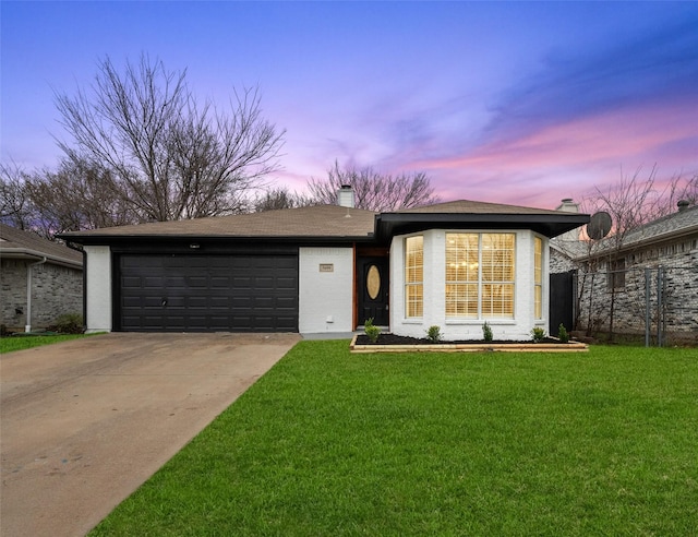 view of front of home featuring a garage and a lawn