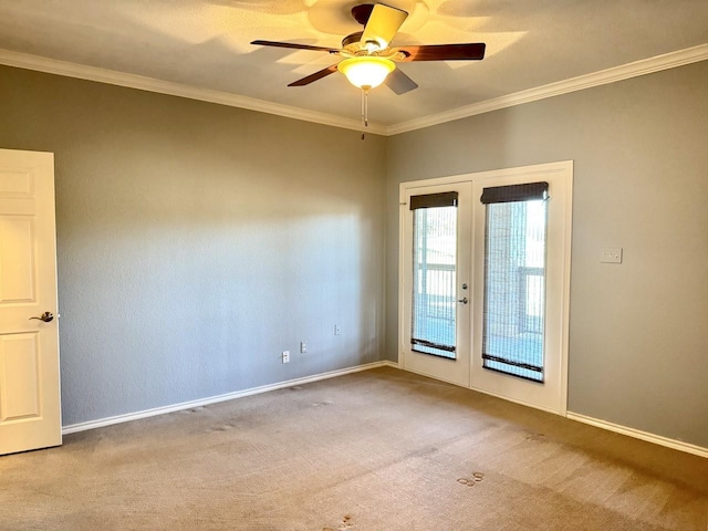 carpeted spare room featuring french doors, ceiling fan, and crown molding