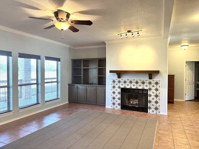 unfurnished living room with light tile patterned flooring, crown molding, a fireplace, and a textured ceiling