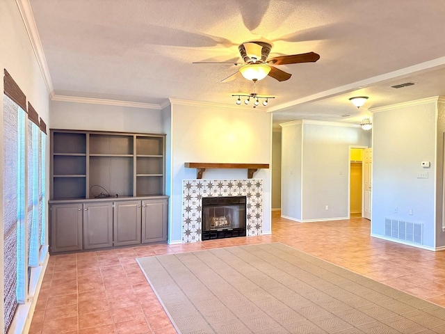 unfurnished living room with ornamental molding, a tile fireplace, ceiling fan, and light tile patterned flooring