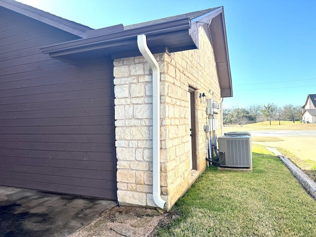 view of side of property with a yard and central air condition unit