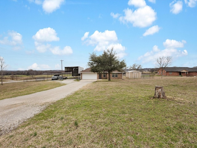 view of yard with a carport, a shed, and a rural view