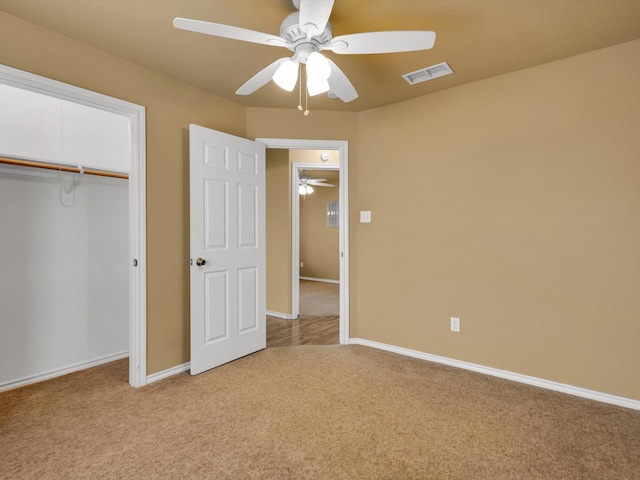 unfurnished bedroom featuring light carpet, a closet, and ceiling fan