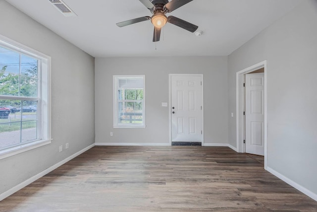 unfurnished room with ceiling fan, plenty of natural light, and wood-type flooring