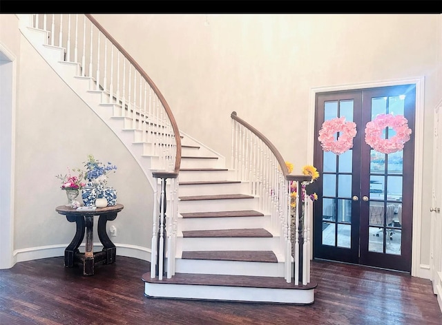 foyer entrance featuring dark wood-type flooring, french doors, and a high ceiling