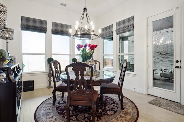 dining area with an inviting chandelier and light wood-type flooring