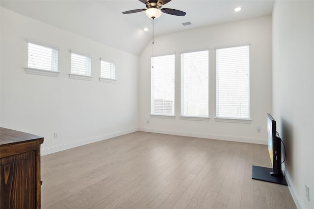 unfurnished living room with lofted ceiling, a wealth of natural light, ceiling fan, and light hardwood / wood-style flooring