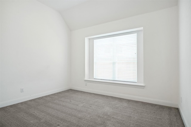 carpeted spare room with lofted ceiling