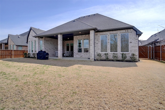 rear view of property featuring a yard and a patio