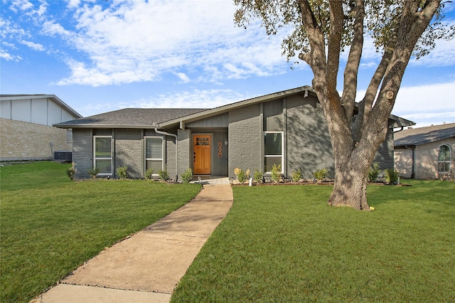 ranch-style house featuring cooling unit and a front lawn