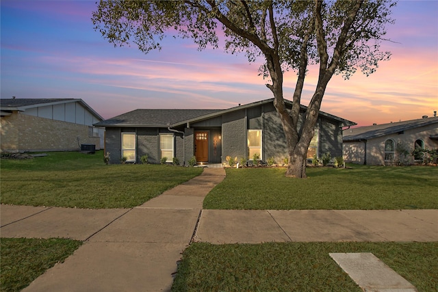 single story home featuring central AC and a lawn