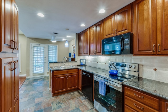 kitchen featuring decorative light fixtures, black appliances, sink, dark stone counters, and kitchen peninsula