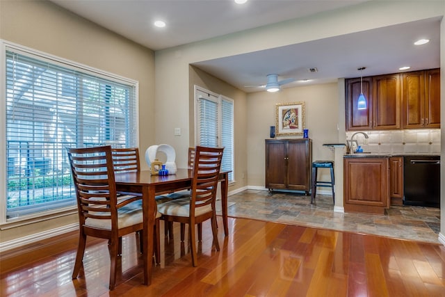 dining space featuring ceiling fan, sink, and dark hardwood / wood-style floors