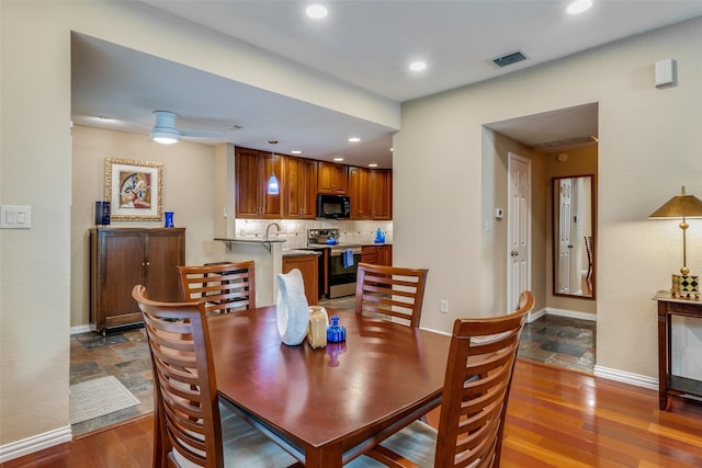 dining space with hardwood / wood-style floors and ceiling fan