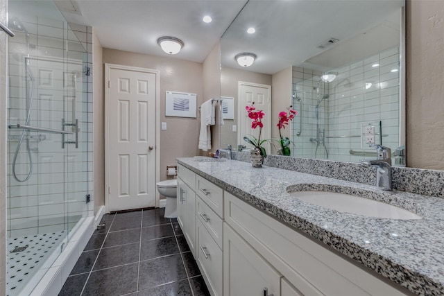 bathroom with tile patterned flooring, vanity, an enclosed shower, and toilet