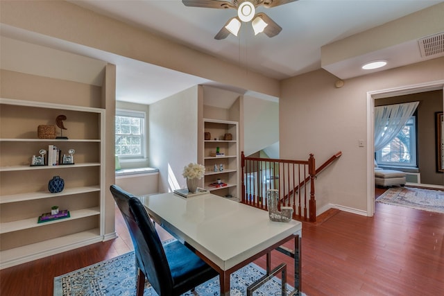 office featuring wood-type flooring, ceiling fan, and built in shelves