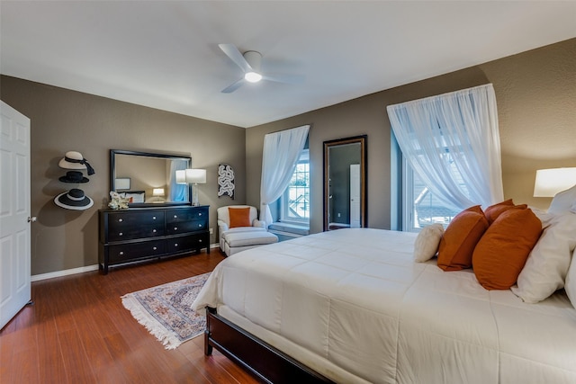 bedroom with dark hardwood / wood-style flooring and ceiling fan