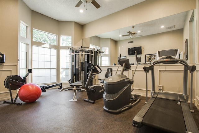 gym featuring a textured ceiling and ceiling fan