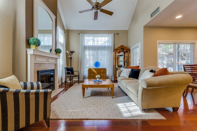 living room with wood-type flooring, high vaulted ceiling, ceiling fan, and a high end fireplace