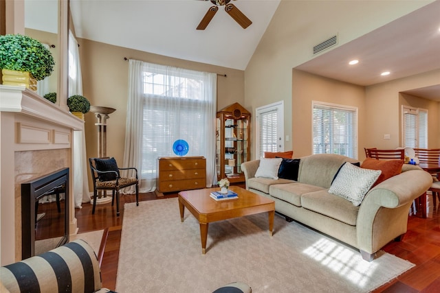 living room with plenty of natural light, dark hardwood / wood-style floors, high vaulted ceiling, and a high end fireplace