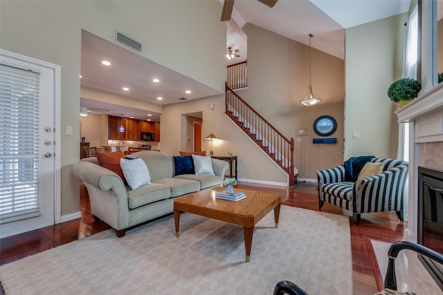 living room featuring a towering ceiling and light wood-type flooring