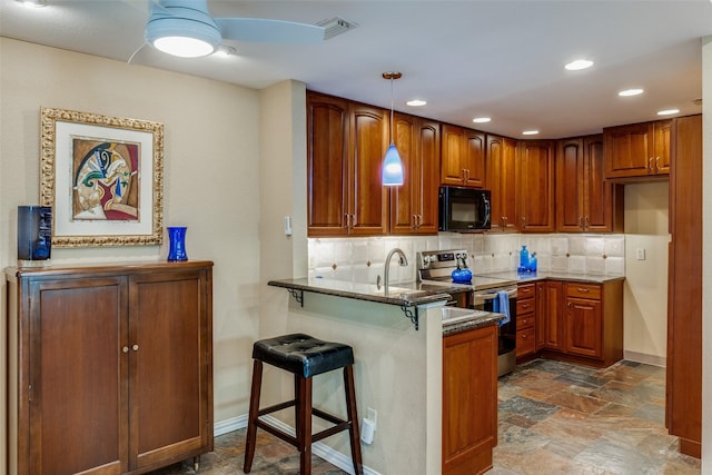 kitchen featuring a kitchen bar, stainless steel electric range oven, kitchen peninsula, pendant lighting, and backsplash