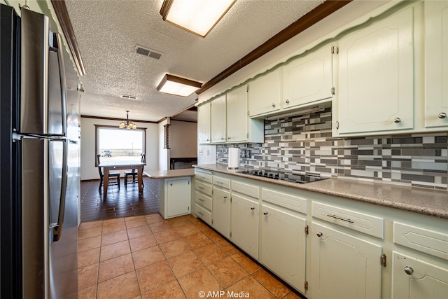 kitchen with light tile patterned floors, stainless steel refrigerator, kitchen peninsula, black electric stovetop, and decorative backsplash