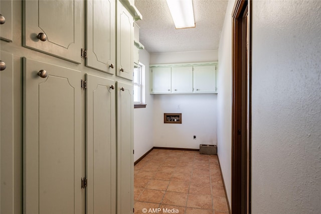 laundry area with hookup for a washing machine, cabinets, a textured ceiling, light tile patterned flooring, and hookup for an electric dryer