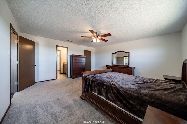 bedroom featuring ceiling fan, light colored carpet, and a textured ceiling