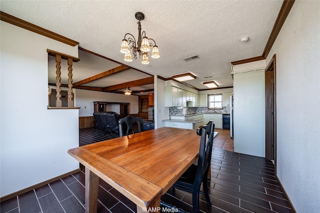 dining space featuring crown molding, sink, ceiling fan with notable chandelier, and a textured ceiling