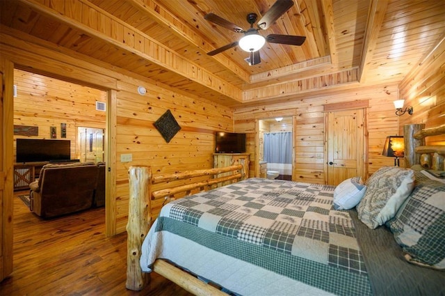 bedroom with wood ceiling, a tray ceiling, hardwood / wood-style floors, and wood walls