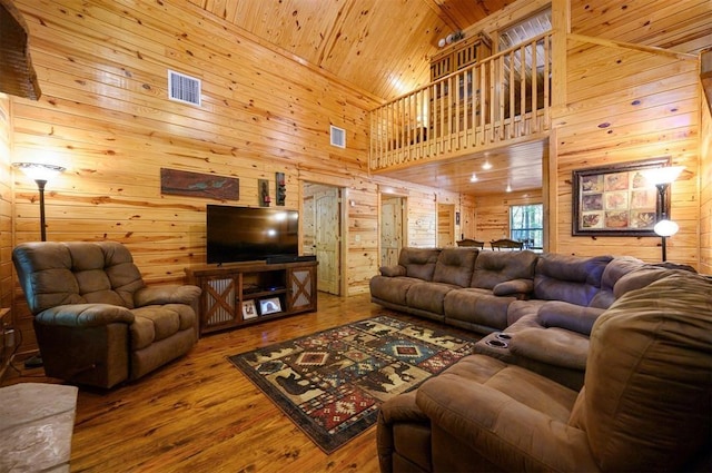 living room with wood ceiling, wooden walls, wood-type flooring, and a high ceiling