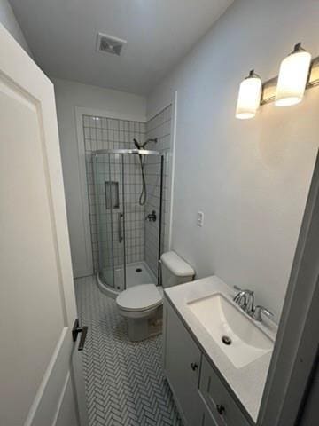 bathroom with vanity, toilet, tile patterned floors, and walk in shower