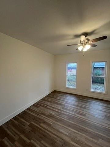 empty room with dark wood-type flooring and ceiling fan