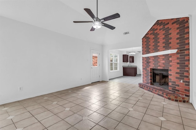 1308 Abbott Dr, Irving, TX 75060 - unfurnished living room featuring lofted ceiling, a ceiling fan, a brick fireplace, light tile patterned floors, and a chandelier