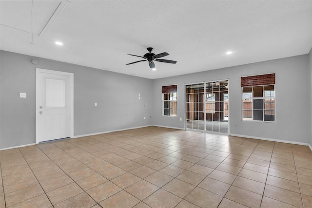 tiled empty room with a textured ceiling and ceiling fan