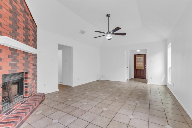 unfurnished living room featuring lofted ceiling, a brick fireplace, light tile patterned floors, and ceiling fan