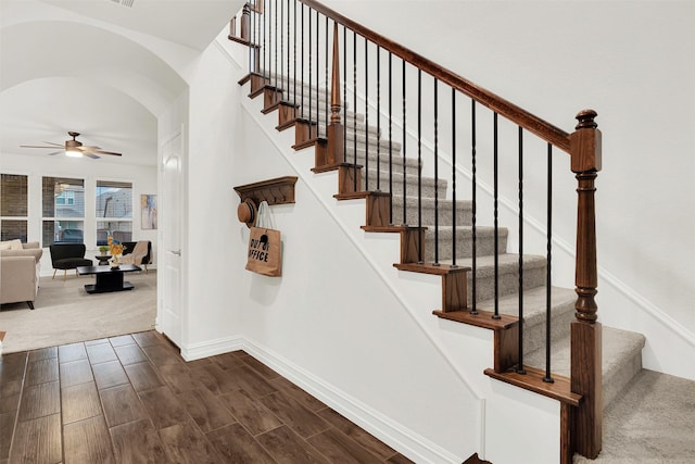 staircase with hardwood / wood-style flooring and ceiling fan