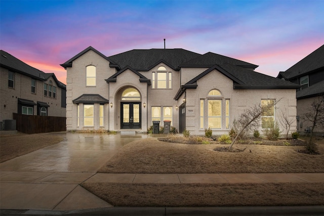 french provincial home featuring central AC and french doors