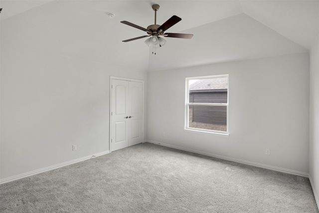 carpeted empty room featuring lofted ceiling and ceiling fan