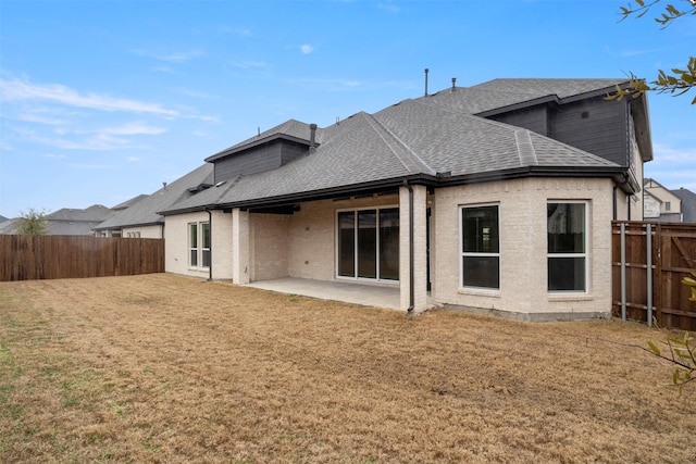 rear view of property with a yard and a patio