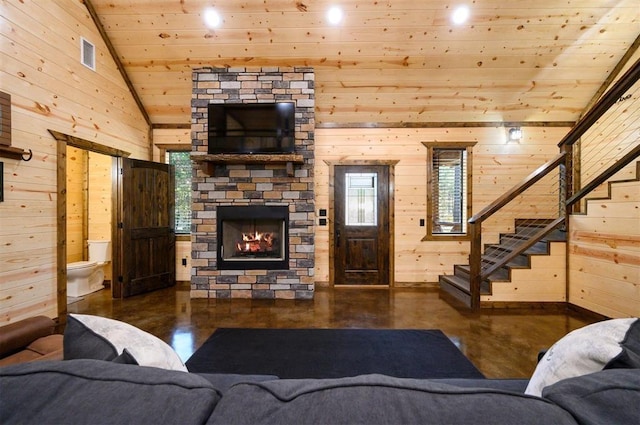 living room with wood ceiling, a stone fireplace, high vaulted ceiling, and wood walls