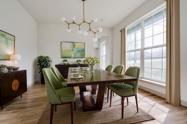 dining space with an inviting chandelier and light hardwood / wood-style floors