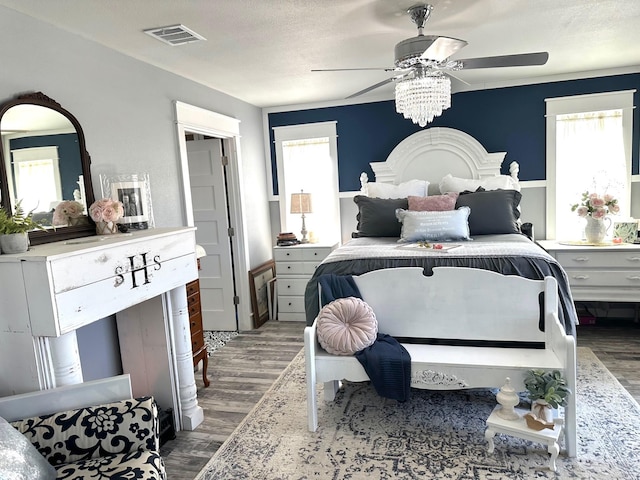 bedroom with hardwood / wood-style flooring, a textured ceiling, and ceiling fan