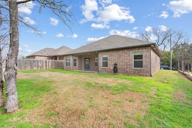 back of property with a patio area and a lawn