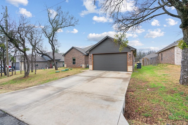 view of front of house with central AC unit, a garage, and a front yard