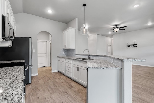 kitchen with stainless steel appliances, sink, white cabinets, and kitchen peninsula